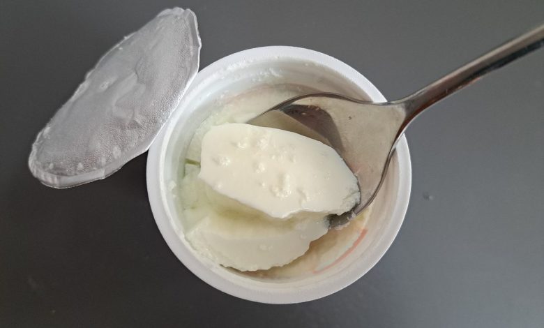 Acik yogurt kabinda kasikla alinan kalin kivamli yogurt